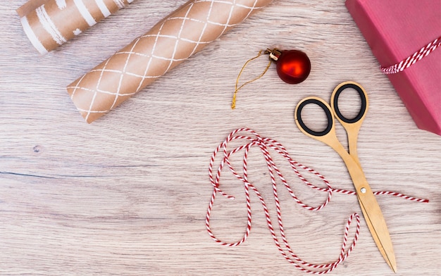 Foto gratuita regalo avvolto vicino a palla di natale, filo e forbici