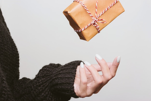 Gift wrapped in kraft paper falls into the hands of a girl. toss a box