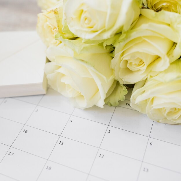 gift and yellow roses bouquet on calendar