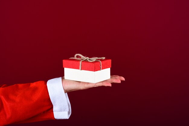 Gifts box on woman hand dressed with santa claus dress