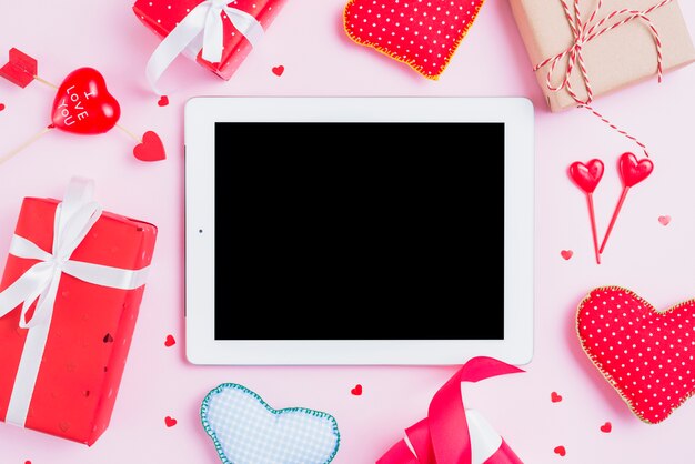 Gifts and hearts around tablet