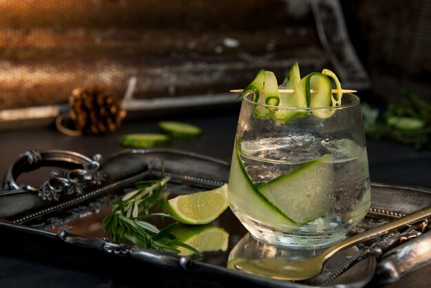 Gin & tonic in the transparent glass with a slice of lime next to it