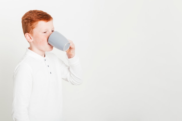 マグカップから飲む生姜少年