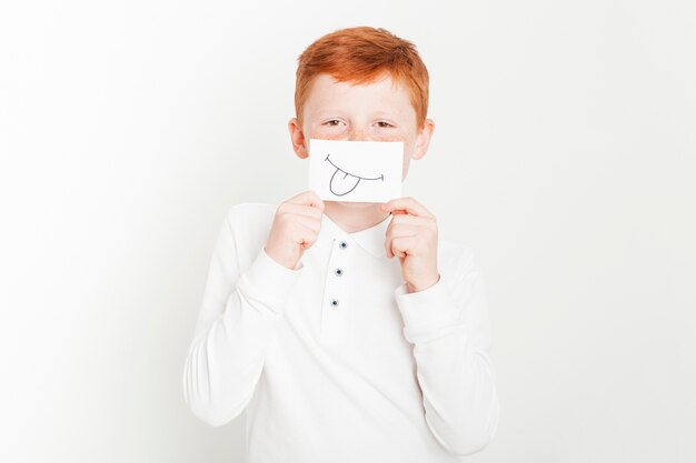 Ginger boy holding card in front of face