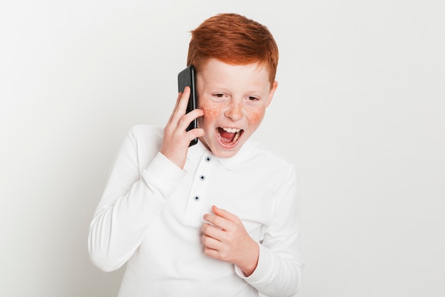 Ginger boy screaming while talking on smartphone