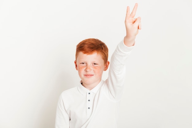 Ginger boy showing two fingers