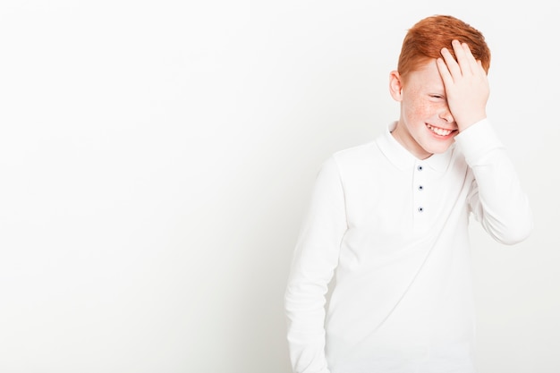 Ginger boy touching his forehead