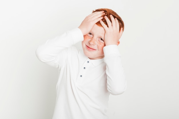 Ginger boy touching his head