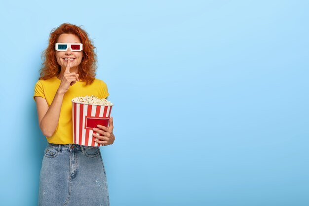 ginger charming girl holds bucket with popcorn