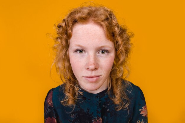 Ginger curly young woman looking at camera