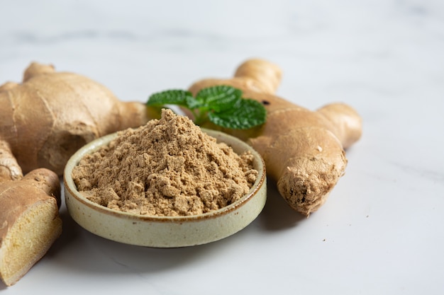 Ginger root and ginger powder on table Free Photo