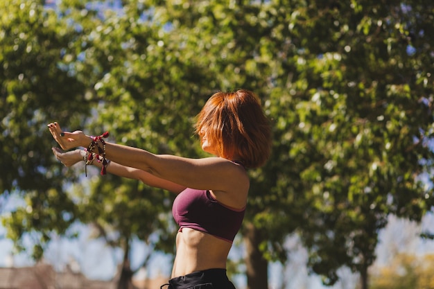 Foto gratuita donna dello zenzero che fa yoga in giornata di sole