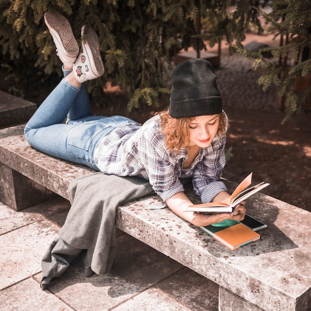 Ginger woman in plaid shirt reading book