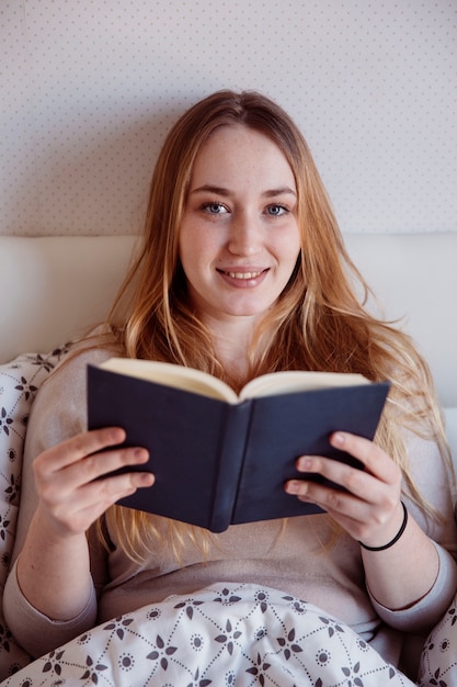 Ginger woman reading in bed