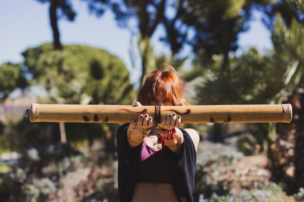 Ginger woman showing bamboo stick