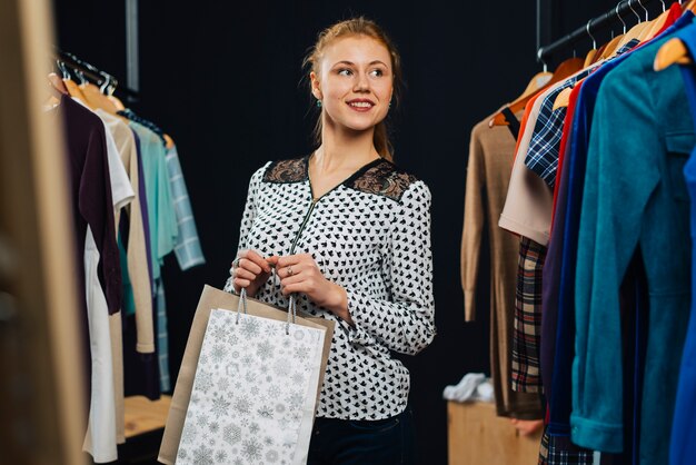 ginger woman with paper bags in shop