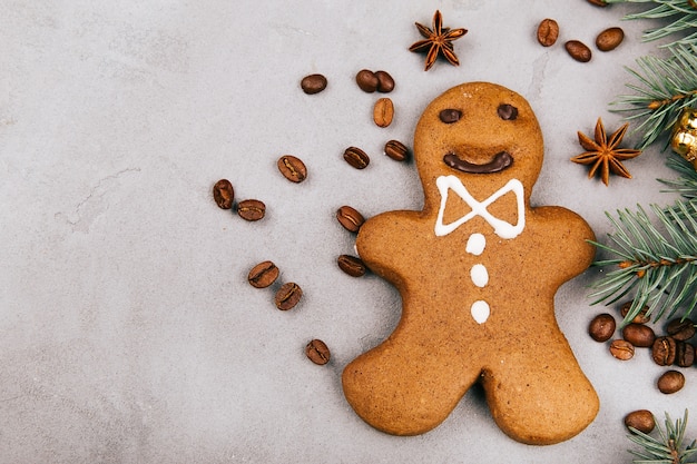 Gingerbread, coffee beans and fir lie on grey floor