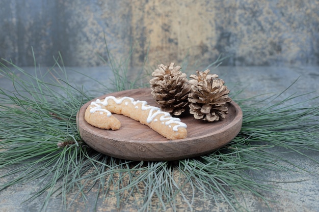 진저 쿠키와 나무 접시에 pinecones입니다. 고품질 사진