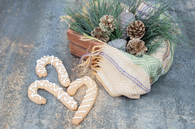 Gingerbread cookies and basket of Christmas decors on marble surface. High quality photo