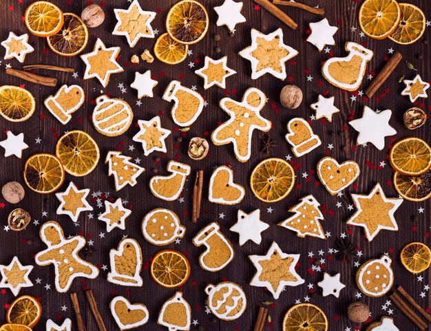 Gingerbread cookies christmas new year oranges cinnamon on wooden table