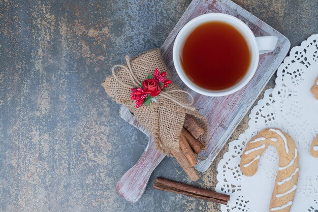 Gingerbread cookies, cinnamon and cup of tea on marble table. High quality photo
