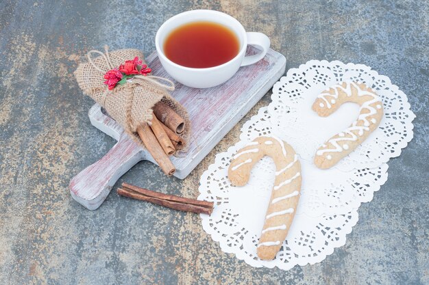 大理石のテーブルにジンジャーブレッドクッキー、シナモン、お茶を。高品質の写真