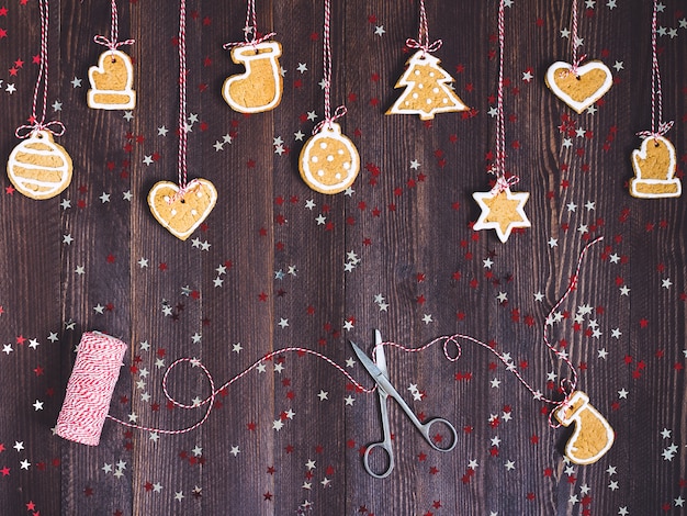 나무 테이블에 가위와 스레드 새 해와 함께 크리스마스 트리 장식 밧줄에 진저 쿠키