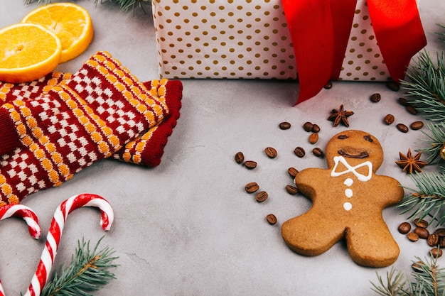Gingerbread, fir, warm gloves, lemon, coffee beans, present box on grey floor