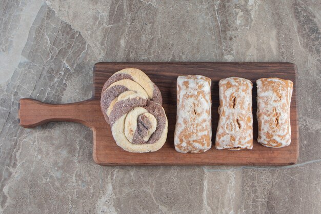 Gingerbread and homemade cookies on a board on marble.