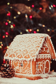 Пряничный домик над расфокусированными огнями рождественской елки