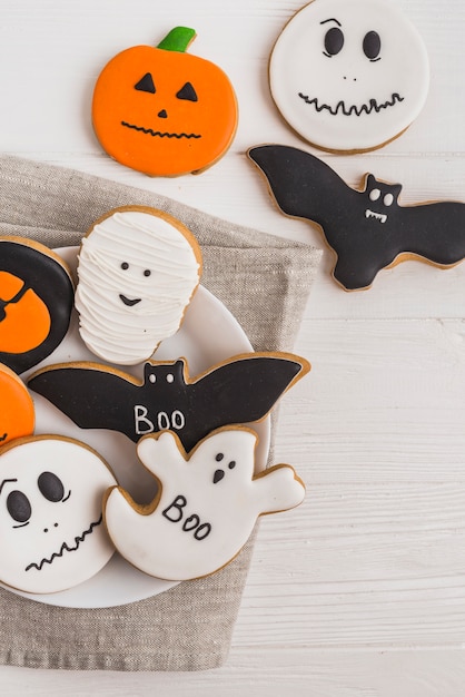 Gingerbread on plate placed on cloth near cookies