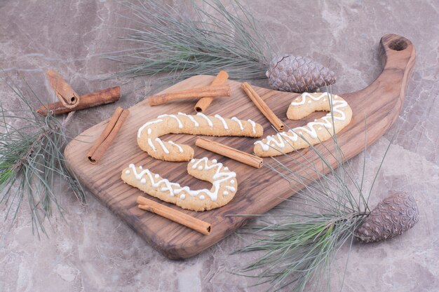 Gingerbread sticks on a wooden board with cinnamons around