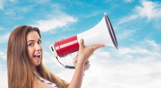 Free photo gir with a megaphone in clouds background