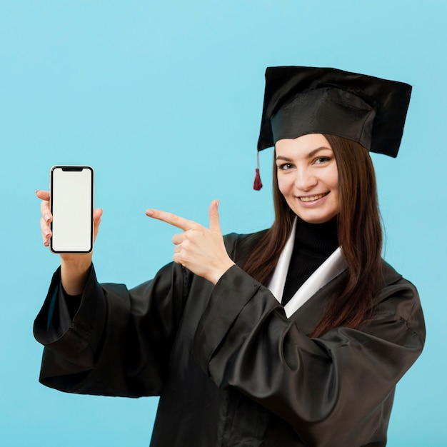 Ragazza in abito accademico con smartphone