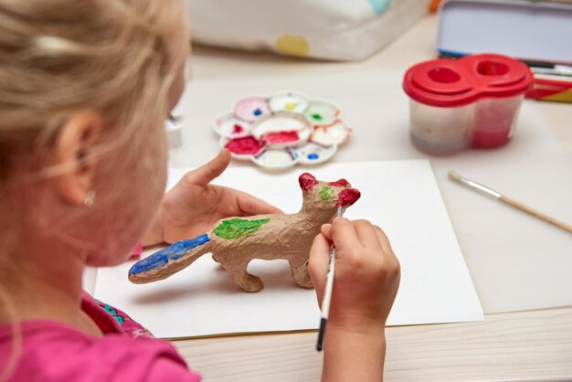 人形を描く少女と少年。ホームスクーリングアートプロジェクトの工芸品を描く子供。