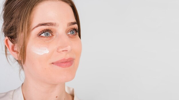 Girl applying herself cosmetic product