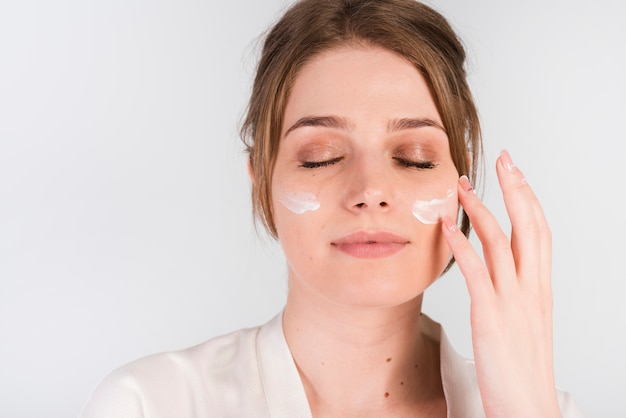 Girl applying herself cosmetic product