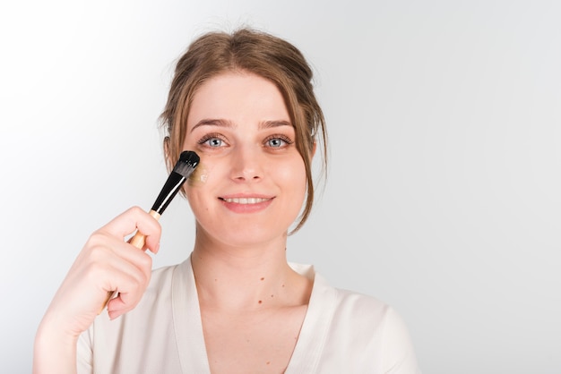 Girl applying herself cosmetic product