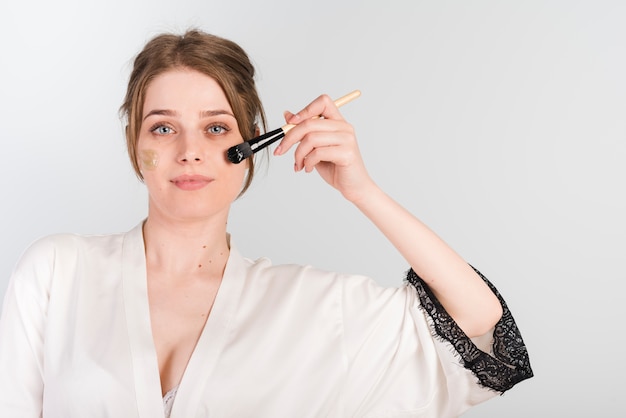 Girl applying herself cosmetic product