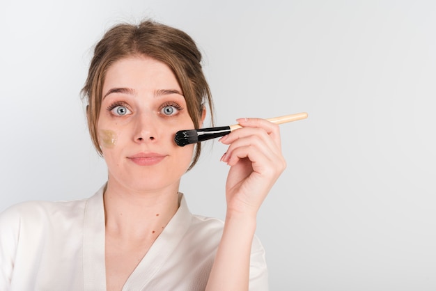 Free photo girl applying herself cosmetic product