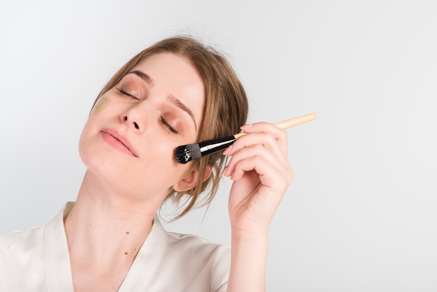 girl applying herself cosmetic product