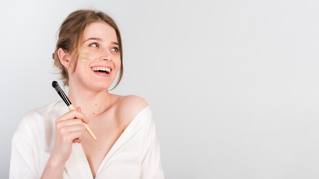 Girl applying herself cosmetic product