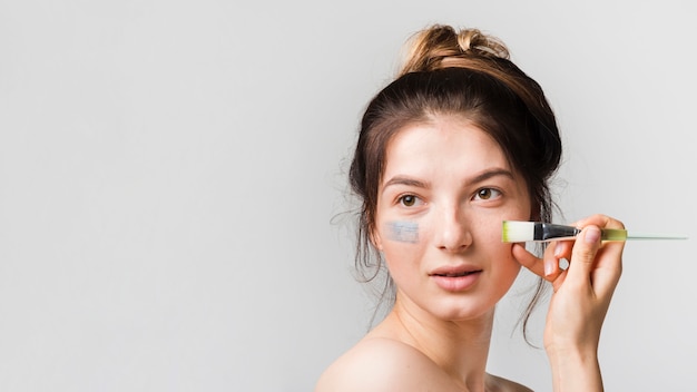 Girl applying herself cosmetic product