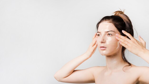 Girl applying herself cosmetic product