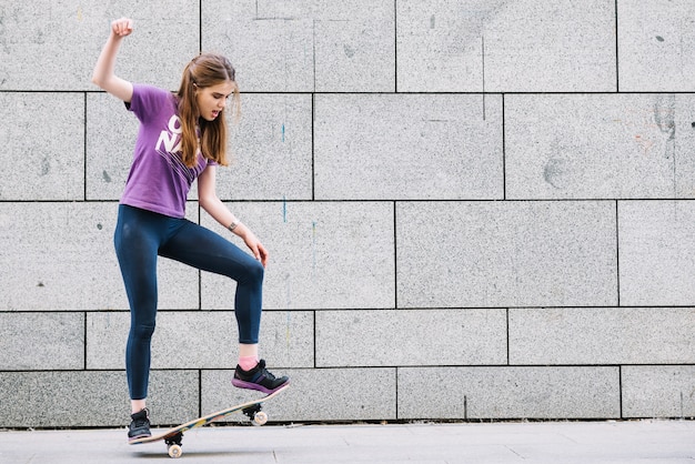 女の子、スケートボードでバランスをとる