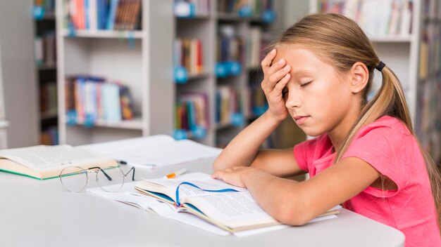 Girl being tired after doing her homework with copy space