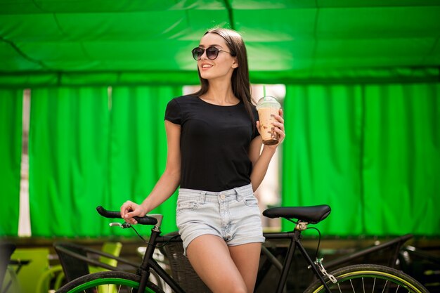 Girl on a bicycle drinking coffee