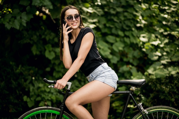 Ragazza su una bicicletta con il telefono