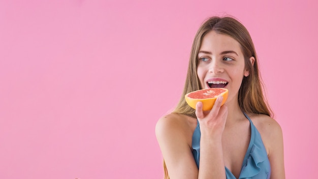 Girl in bikini eating grapefruit