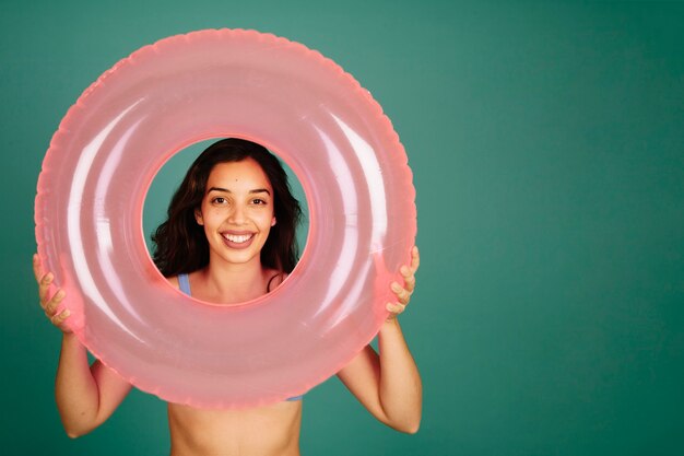 Girl in bikini looking through inflatable ring